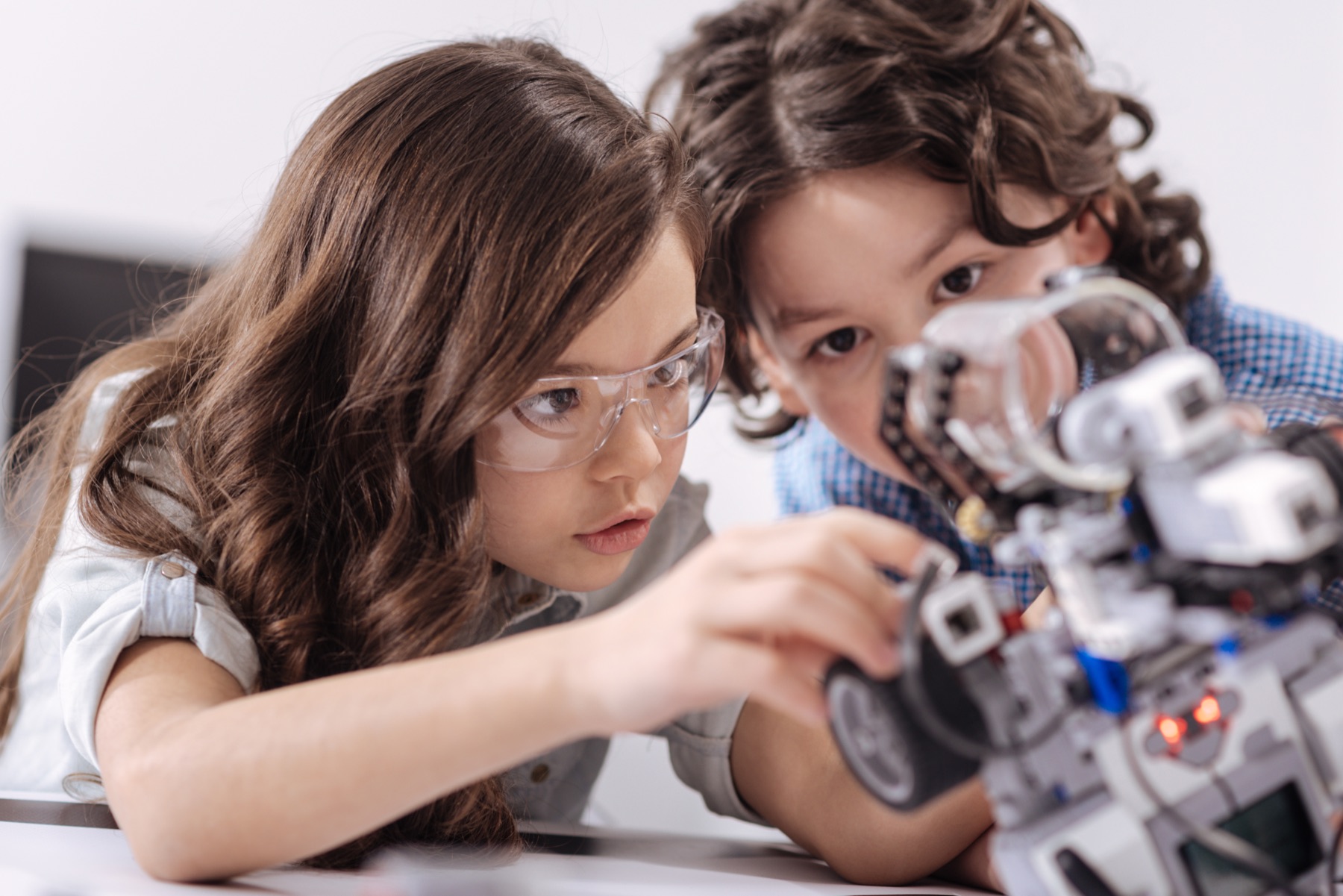 Students wearing safety glasses building and testing an autonomous robot in class
