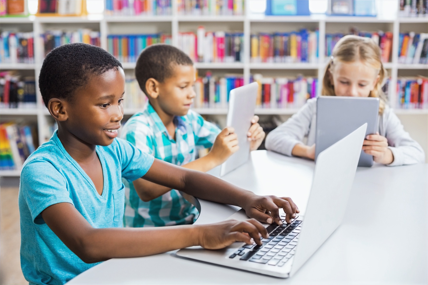 Students collaborating on laptops and tablets in a BC school classroom